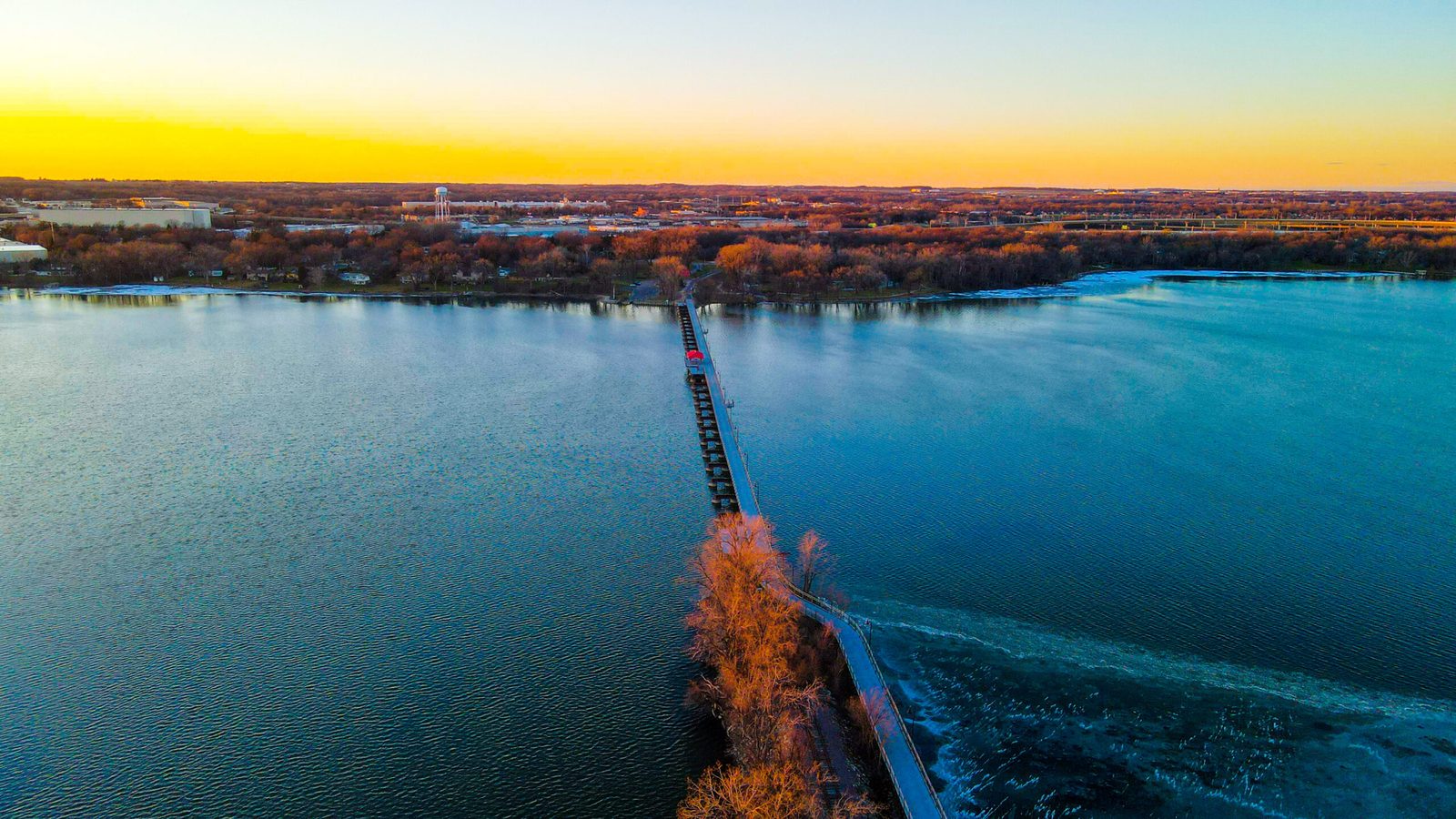 Aerial view of a Fox Cities lake and causeway at sunset.
